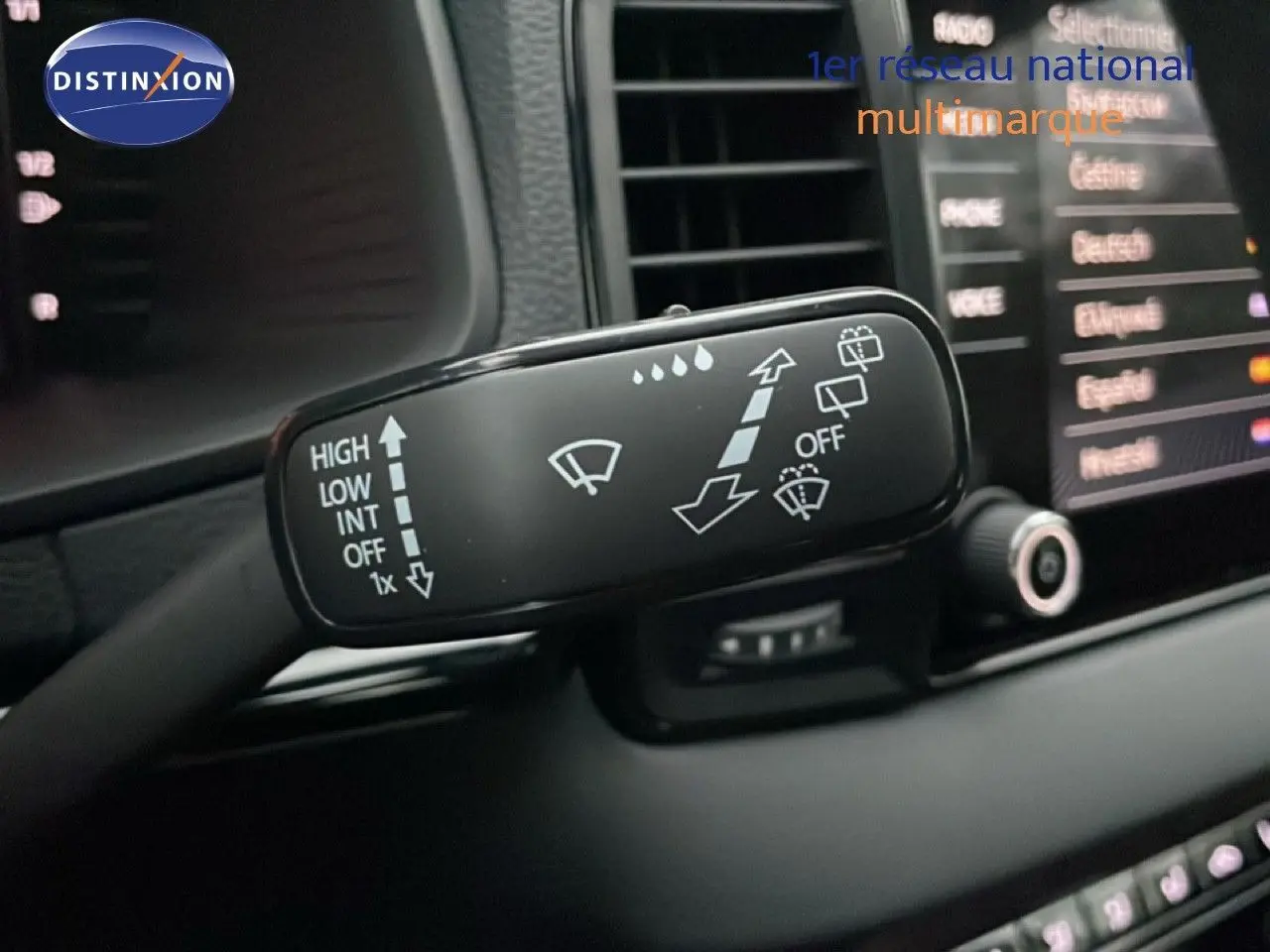 Gros plan sur la commande des essuie-glaces à l'intérieur d'un Skoda Karoq gris argent 2025, tableau de bord en arrière-plan flou.