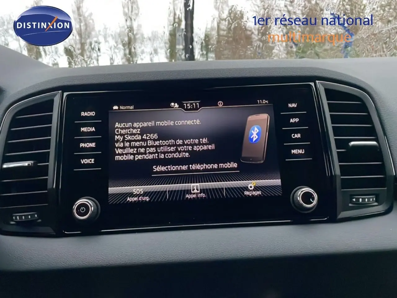Tableau de bord avec écran tactile central du Skoda Karoq gris argent, affichant menu Bluetooth et options connectées.