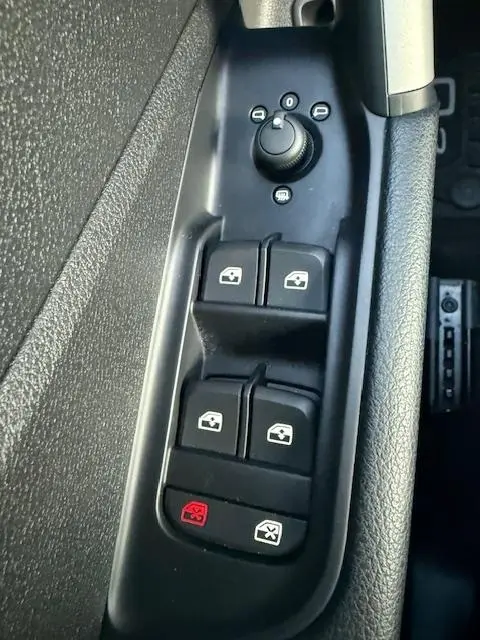 Gros plan sur les commandes de lève-vitres et rétroviseurs noirs côté conducteur de l'Audi Q2 35 TFSI 150 S Line 2023.