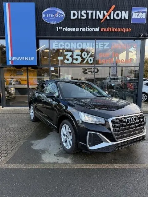Audi Q2 35 TFSI S Line noir vue 3/4 avant, calandre distinctive et phares LED, devant concession multimarque.