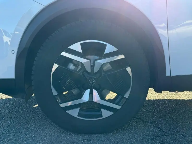Gros plan sur la roue avant gauche avec jante alu au design moderne du Peugeot 2008 gris 2024.