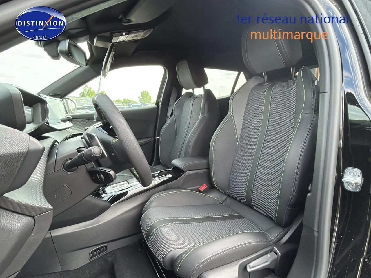 Vue intérieure côté conducteur du Peugeot 2008 noir 2025, sièges sport avec surpiqûres vertes et volant cuir multifonction.