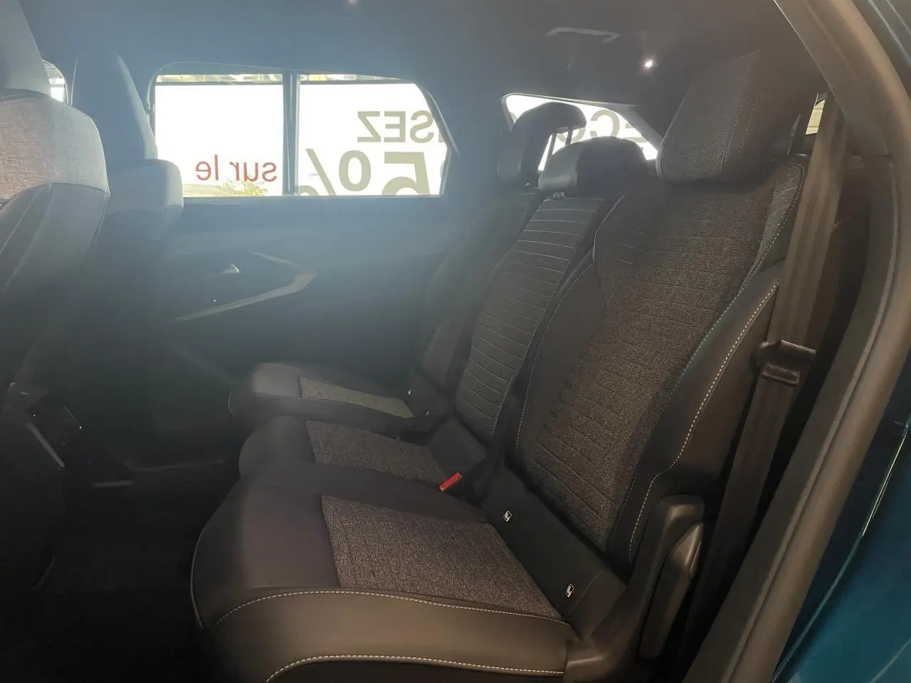 Vue côté droit sur la banquette arrière tissu et cuir du Peugeot 5008 Bleu Obsession avec ceinture de sécurité visible.