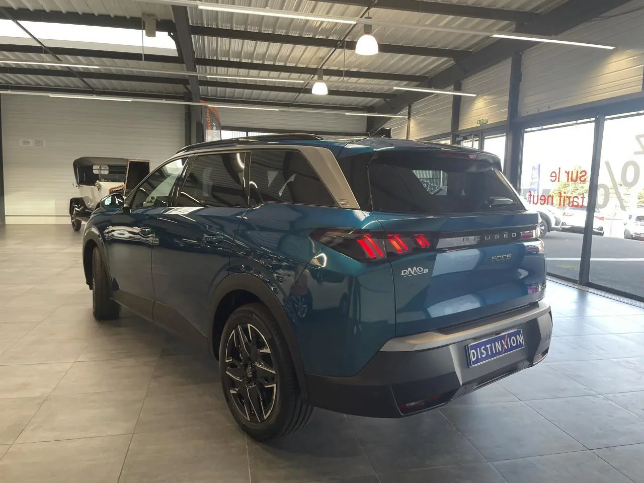 Vue 3/4 arrière droite du Peugeot 5008 bleu Obsession avec feux arrière LED en forme de griffes et jantes alliage 19 pouces.