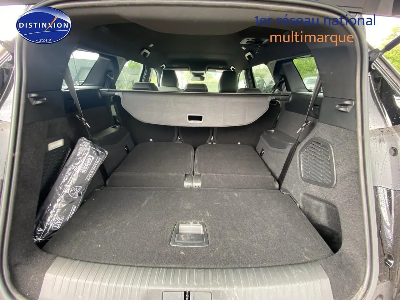 Coffre ouvert du Peugeot 5008 noir vu de l'arrière, sièges arrière rabattus offrant un grand espace de chargement.