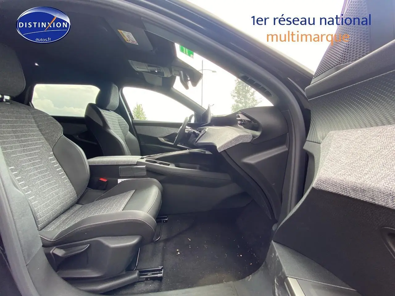 Intérieur avant droit du Peugeot 5008 noir 2025, montrant sièges tissu et cuir, tableau de bord moderne et console centrale.