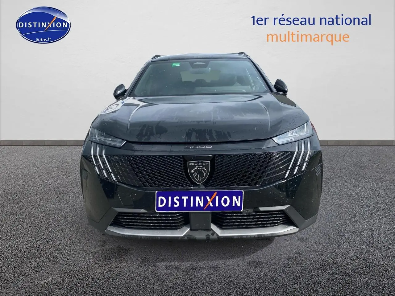 Vue avant d'un Peugeot 5008 noir 2025 avec calandre distinctive et feux LED verticaux allumés.