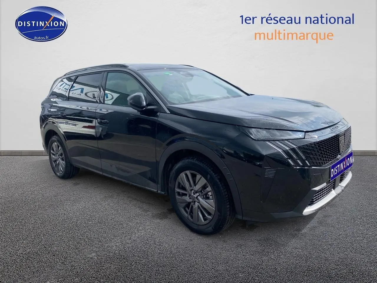 Peugeot 5008 noir vue 3/4 avant droit avec calandre distinctive et jantes alu sur fond neutre.
