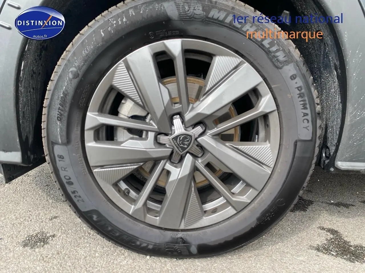 Gros plan sur la roue avant gauche avec jante alu grise du Peugeot 5008 noir Hybrid 145 allure e-dcs6 2025.
