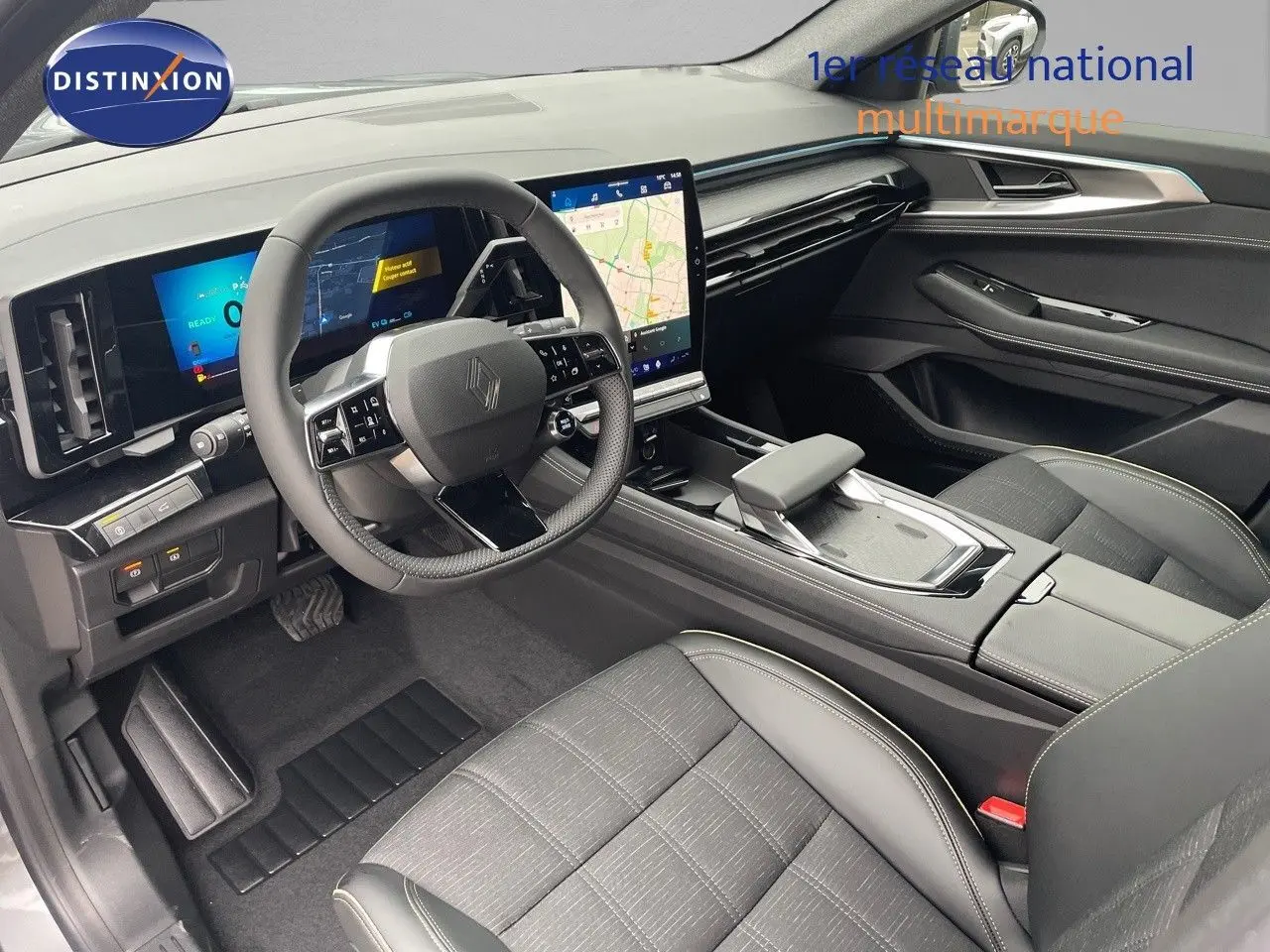 Vue intérieure côté conducteur du Renault Austral gris métal 2025, mettant en valeur le tableau de bord numérique et l’écran tactile central.