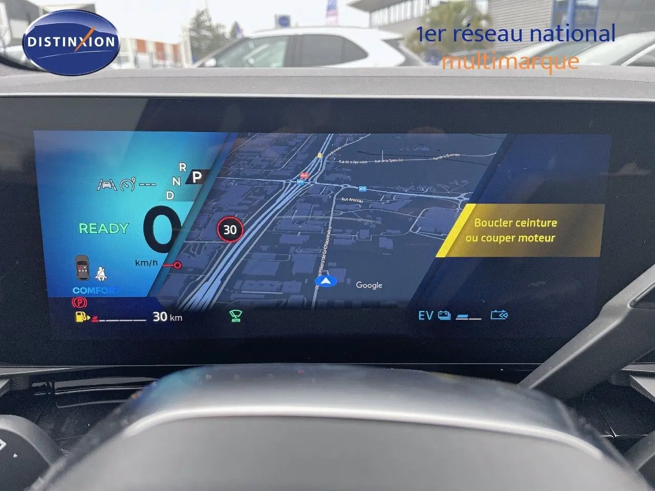 Vue intérieure du tableau de bord numérique du Renault Austral gris métal 2025, affichant la navigation et les alertes de conduite.