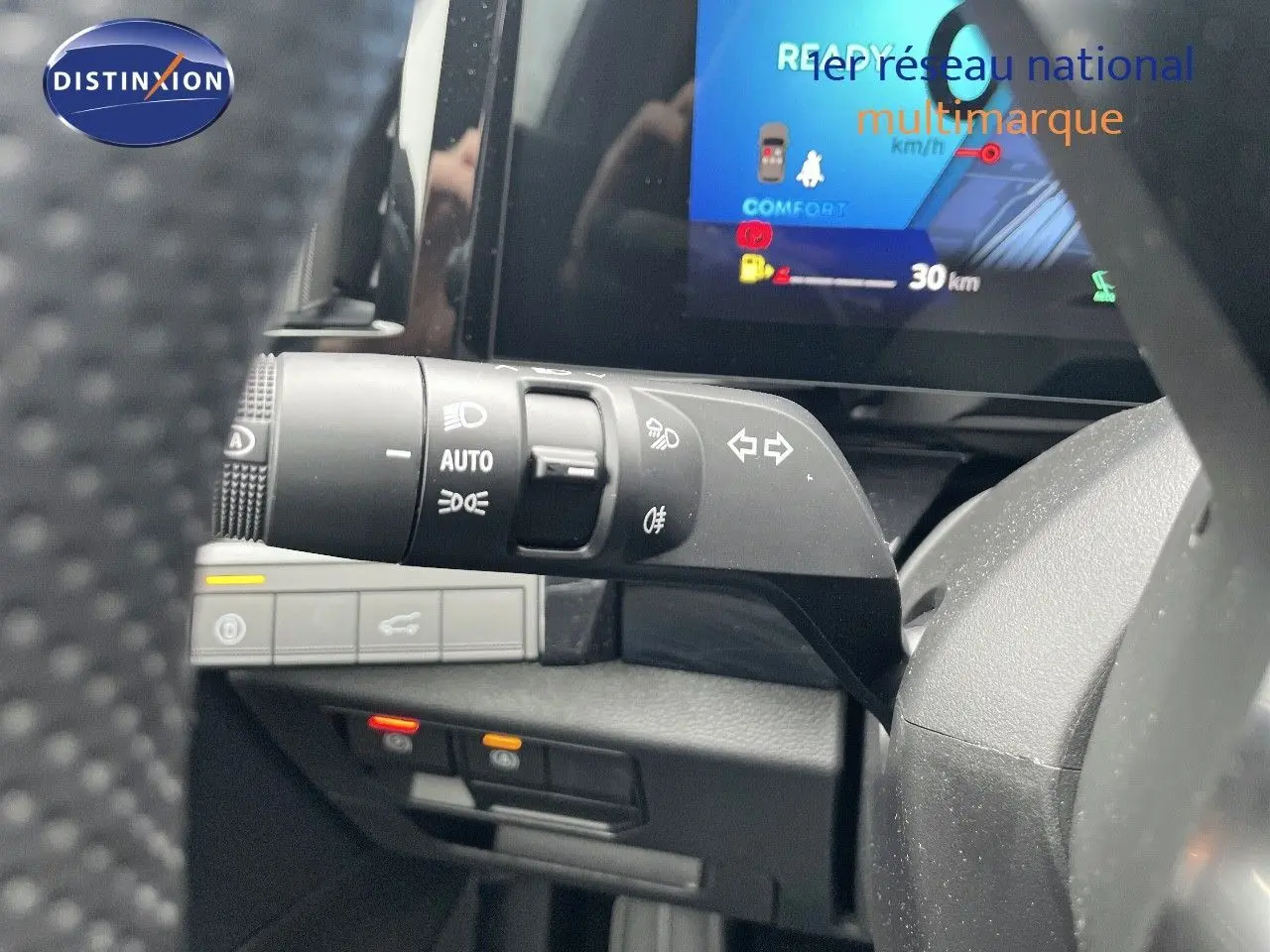 Gros plan sur la commande des feux et clignotants à gauche du volant dans l’habitacle du Renault Austral gris métal 2025.