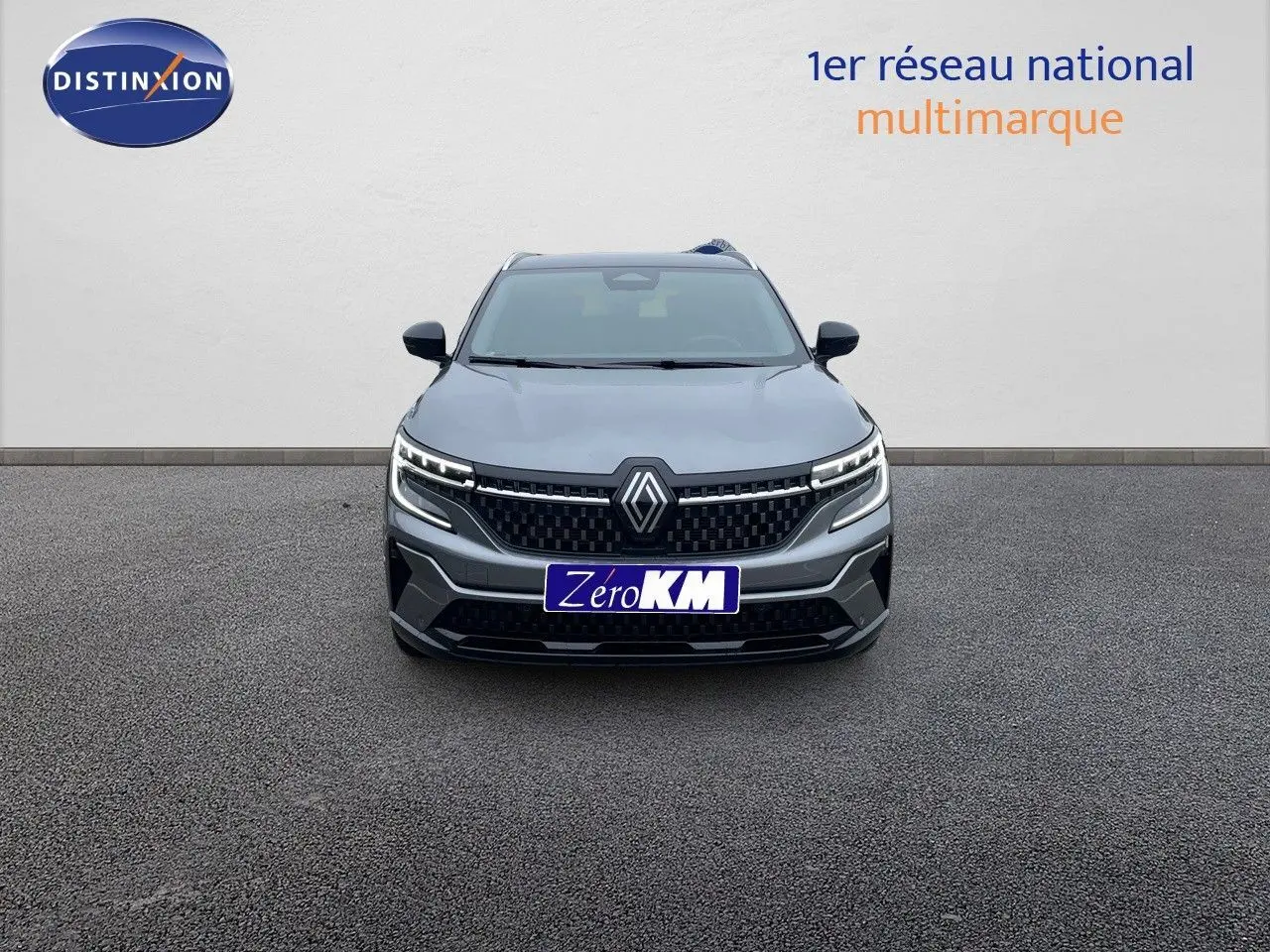 Vue frontale d’un Renault Austral gris métal 2025 avec calandre noire et feux LED allumés sur fond neutre.