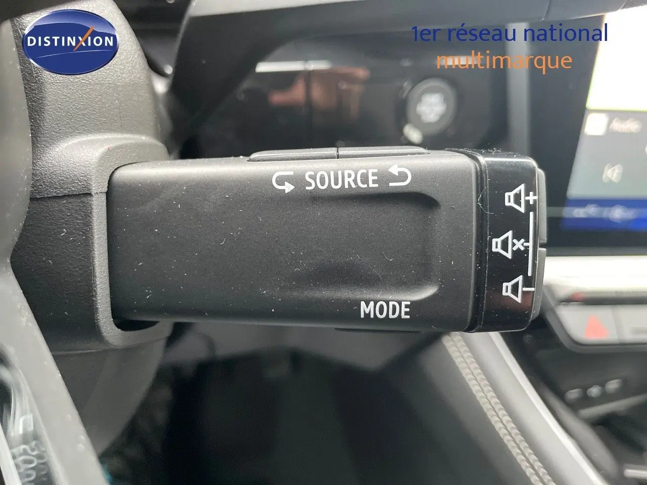 Gros plan sur la commande au volant du Renault Austral 2025, finition Iconic, avec boutons source et mode visibles.