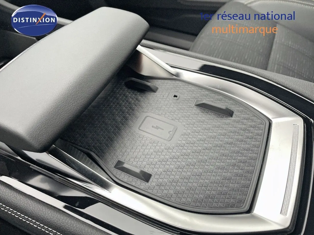 Gros plan sur le chargeur sans fil au centre console du Renault Austral gris métal 2025, finition Iconic.