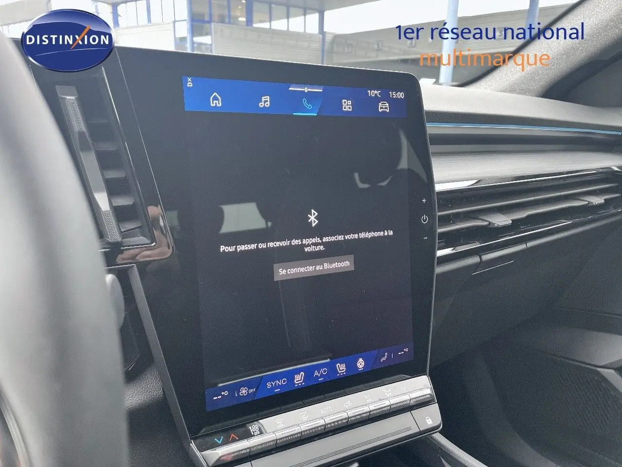 Vue intérieure centrée sur l’écran tactile du tableau de bord du Renault Austral gris métal 2025, avec commandes climatisation visibles.