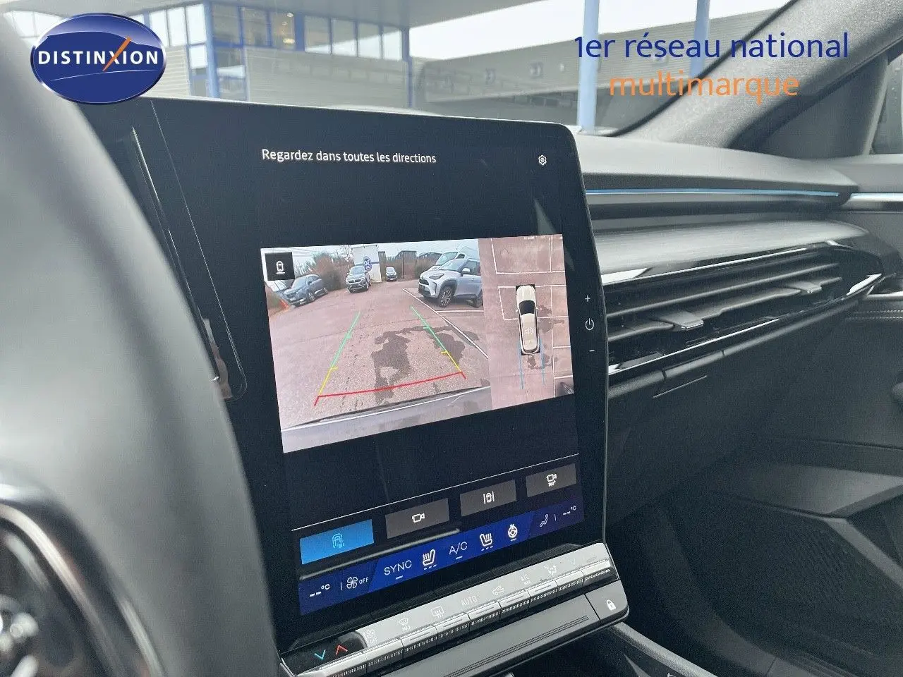 Vue intérieure du tableau de bord du Renault Austral 2025, écran tactile affichant la caméra de recul et l'aide au stationnement.