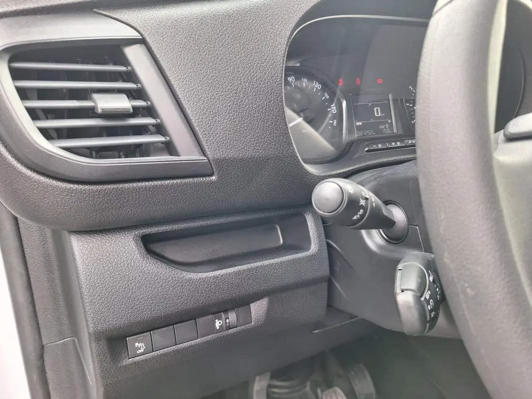 Vue intérieure côté conducteur de l'Opel Vivaro blanc 2025, montrant le tableau de bord et les commandes au volant.