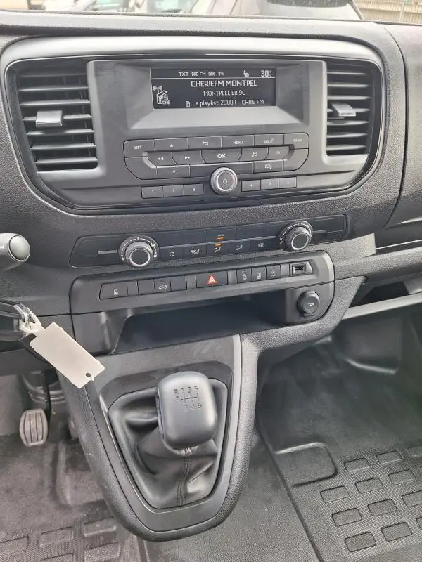 Vue intérieure centrée sur la console et levier de vitesse manuel d’un Opel Vivaro blanc de 2025.