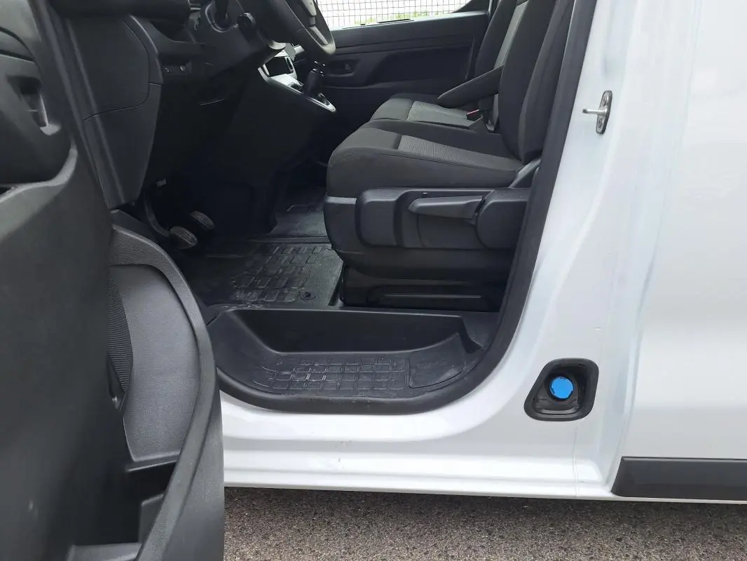 Vue intérieure côté conducteur de l’Opel Vivaro blanc 2025, montrant les sièges et le plancher en caoutchouc.
