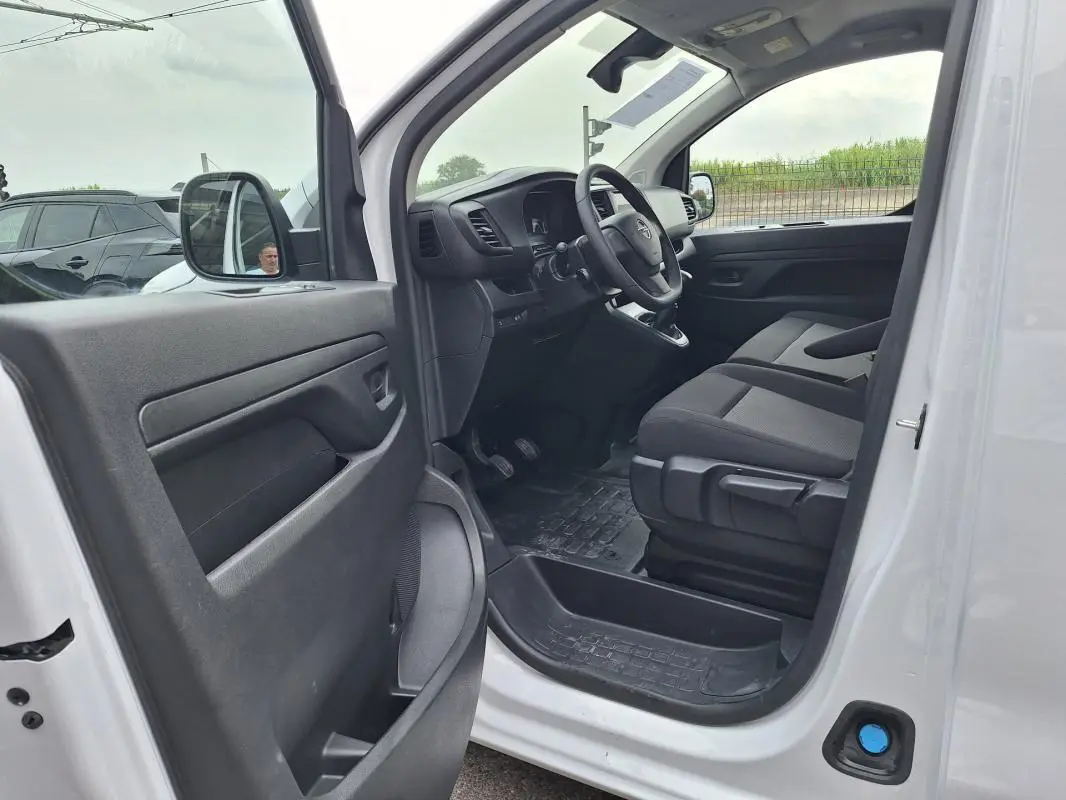 Vue intérieure côté conducteur de l’Opel Vivaro blanc 2025, montrant le tableau de bord et les sièges avant.