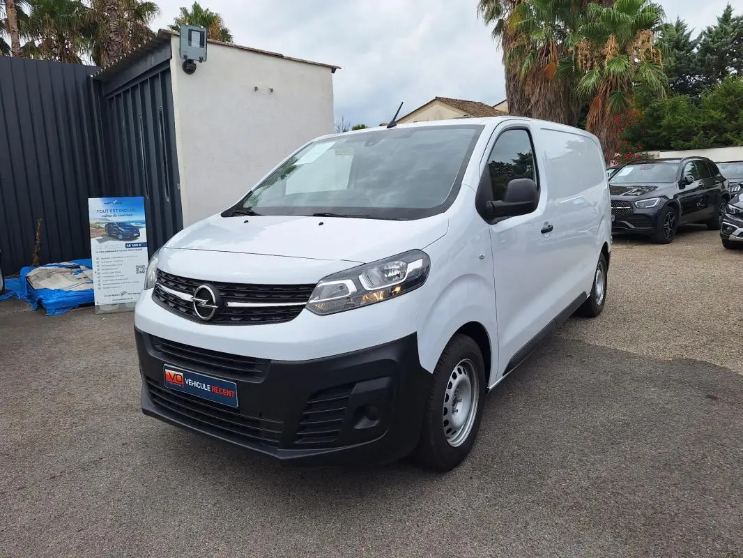 Fourgon Opel Vivaro blanc vu en 3/4 avant droit, avec pare-chocs noir et porte latérale visible.