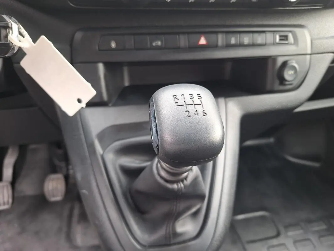 Gros plan sur le levier de vitesses manuel noir de l’Opel Vivaro 2025, intérieur gris sombre.