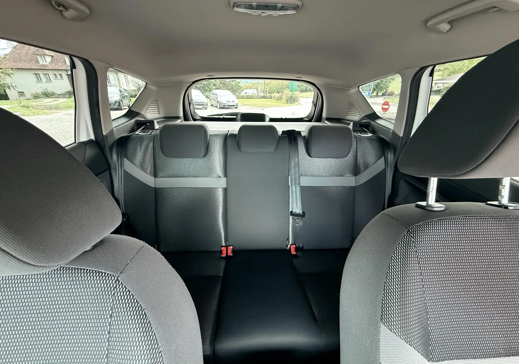 Vue intérieure arrière du Ford Kuga 2012 montrant les sièges arrière en tissu gris et noir avec appuie-têtes et ceinture centrale.