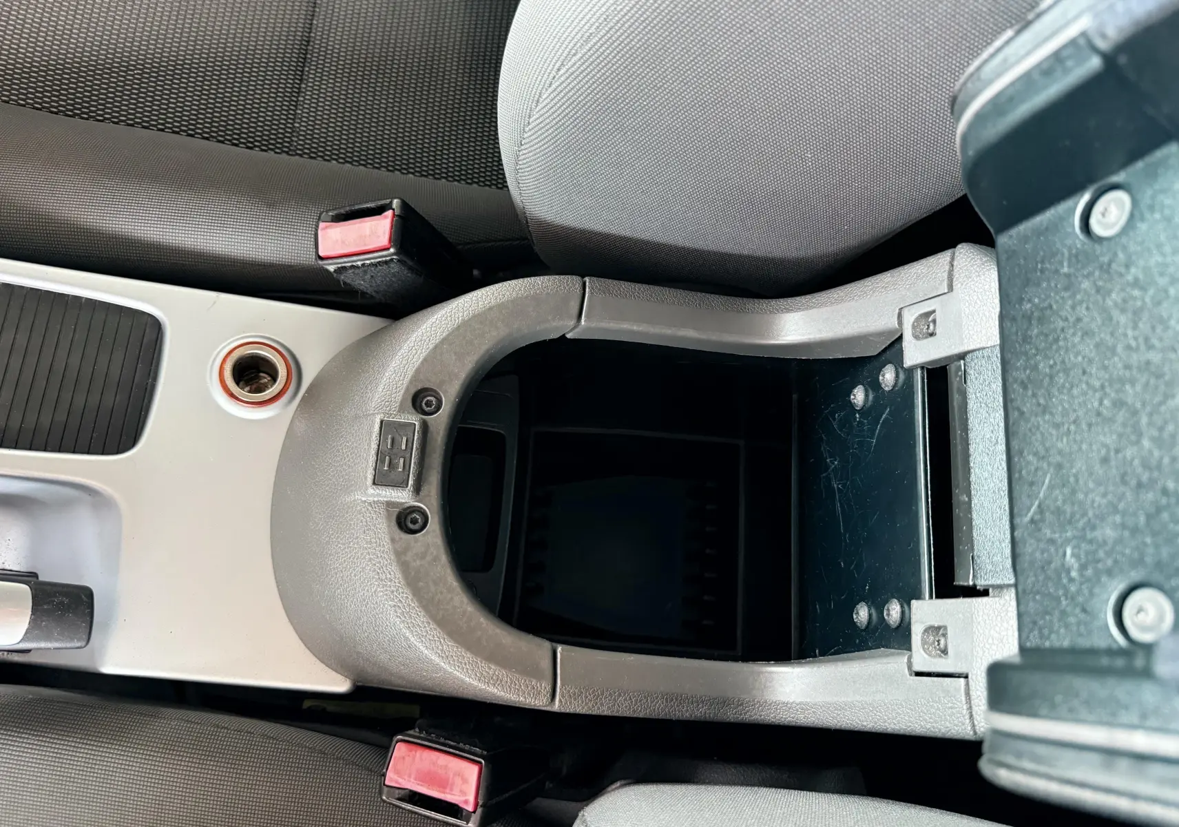 Vue plongeante sur la console centrale ouverte du Ford Kuga 2012 avec accoudoir et sièges en tissu gris noir