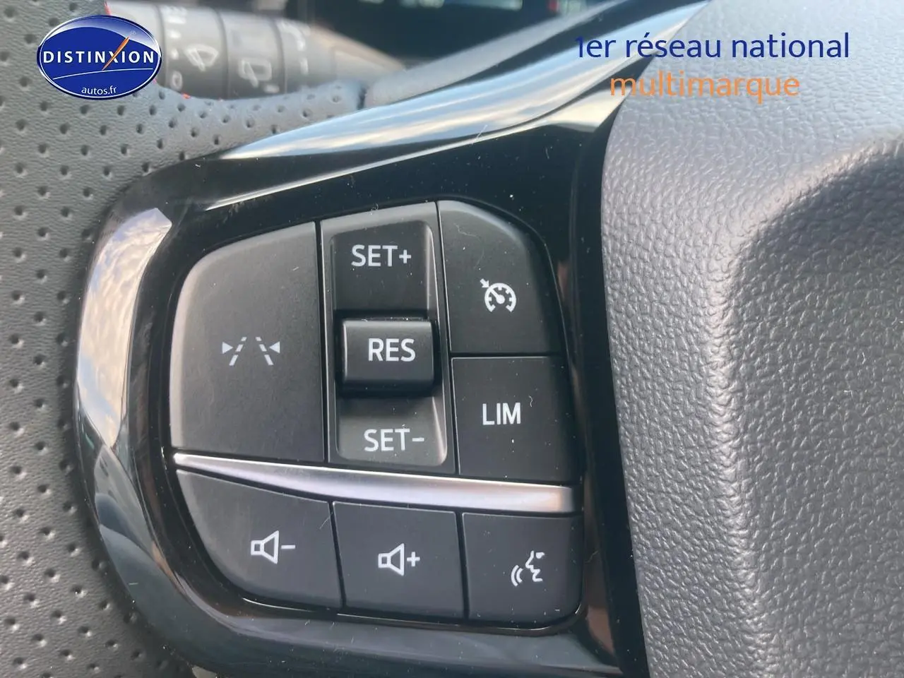 Gros plan sur les commandes au volant du Ford Puma gris cactus 2025, avec régulateur de vitesse et contrôle vocal.