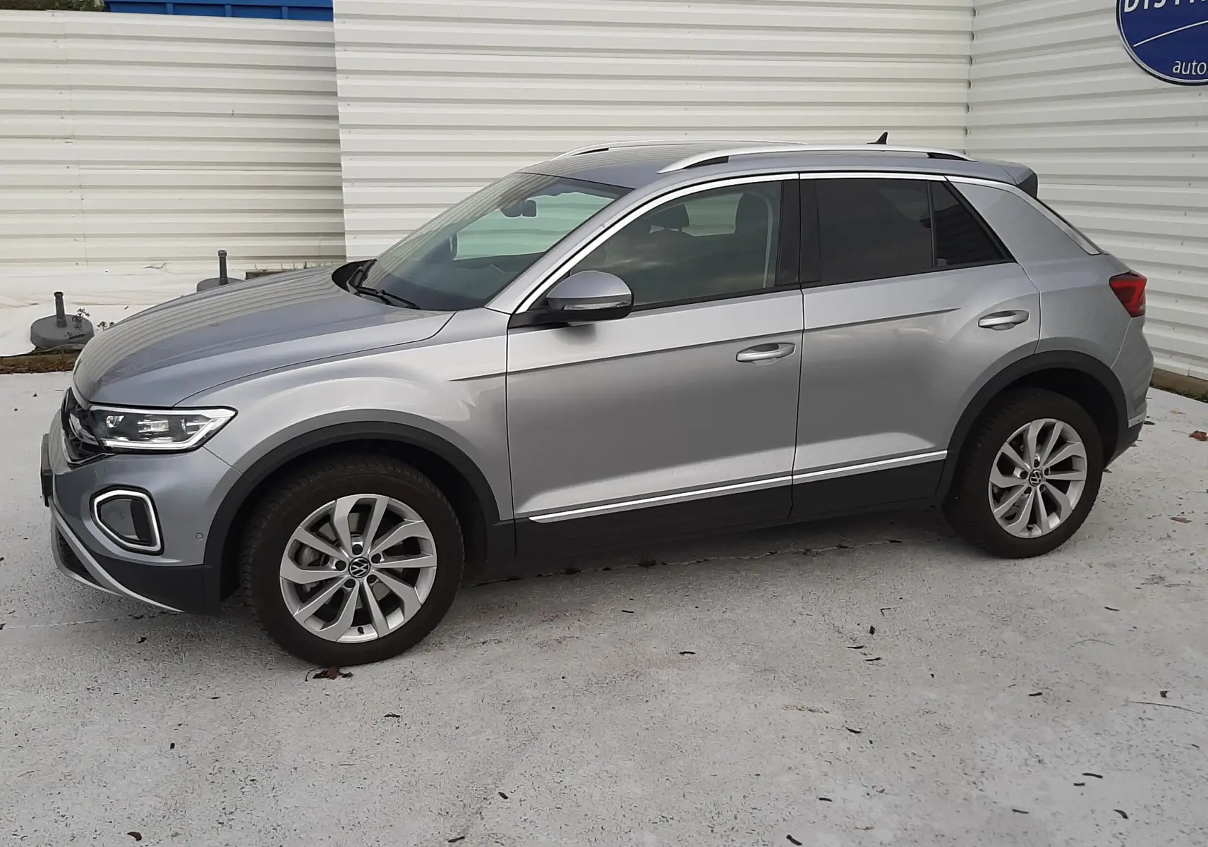 Volkswagen T-Roc gris pyrite vu de profil côté gauche, avec vitres arrière surteintées et jantes alliage.