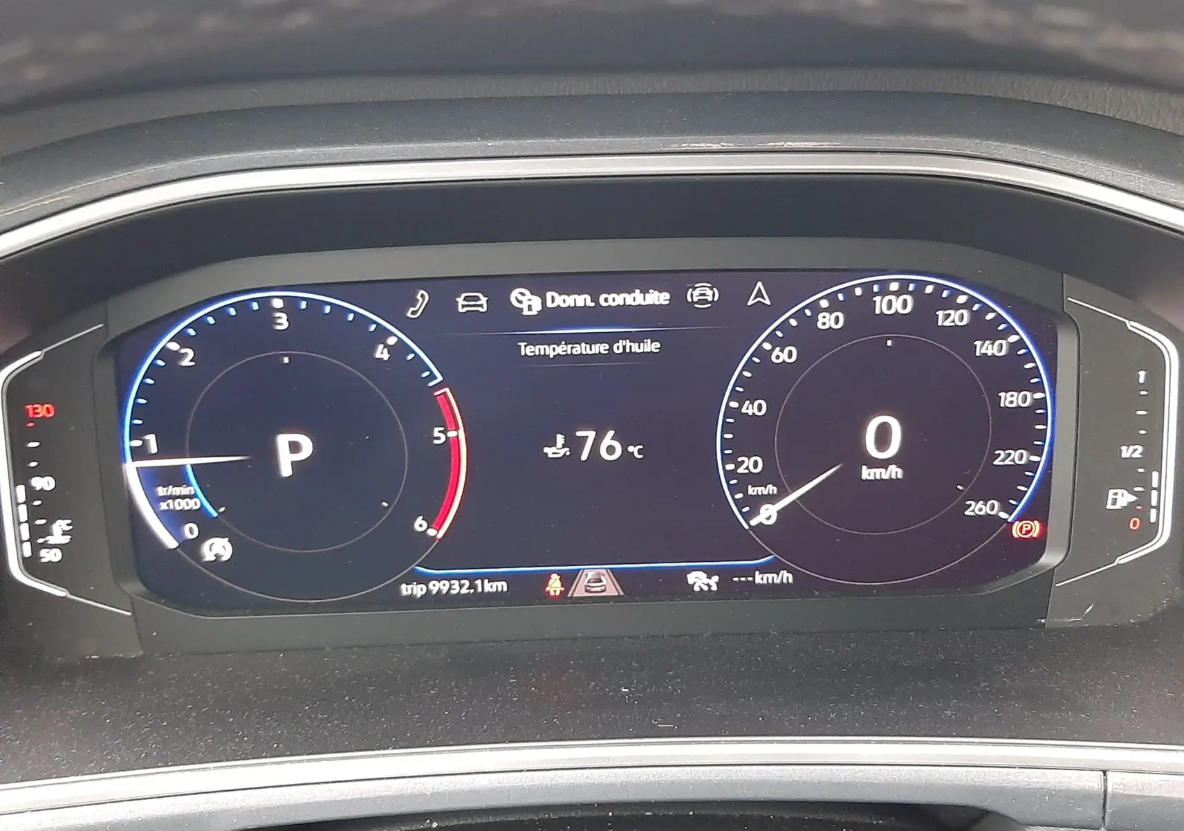 Tableau de bord numérique du Volkswagen T-ROC 2023 affichant la température d'huile à 76°C et le véhicule à l'arrêt.