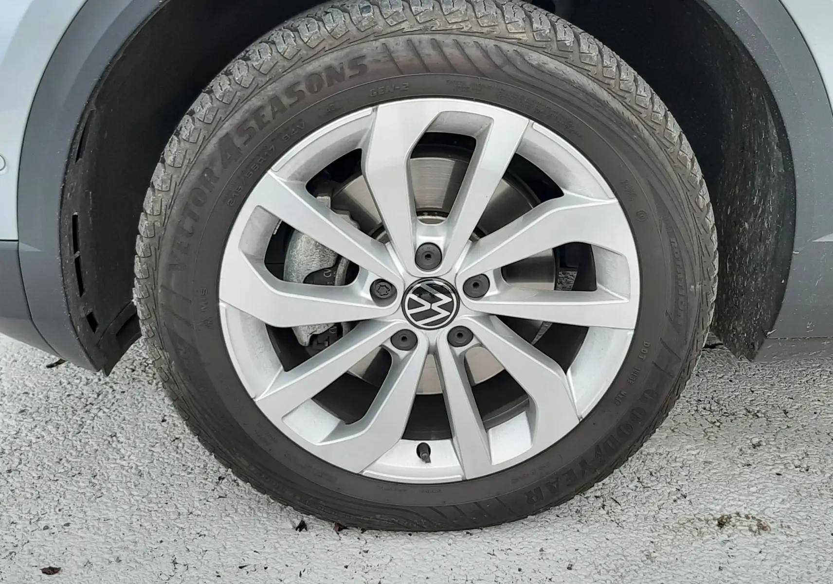 Gros plan sur la roue avant gauche d'un Volkswagen T-Roc gris pyrite avec jante alliage et pneu Goodyear.