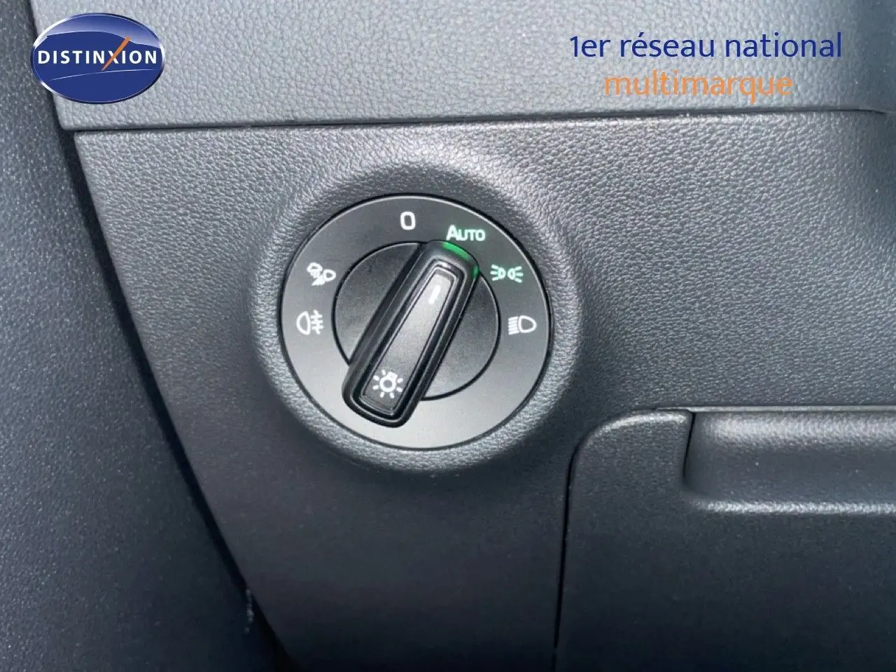 Gros plan sur le bouton de commande des phares dans l’habitacle noir du Skoda Karoq gris argent 2025.