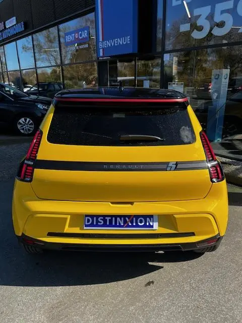 Vue arrière d'une Renault R5 Techno jaune 2024 avec feux LED verticaux et bande noire distinctive.