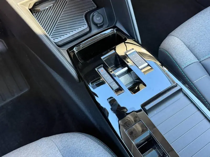 Gros plan sur la console centrale noire brillante avec levier de vitesse automatique dans l’habitacle gris du Citroën C4 2024.