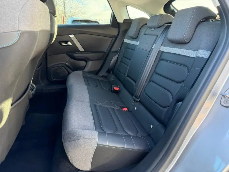 Vue intérieure côté droit des sièges arrière bi-matière gris clair et noir du Citroën C4 2024 Gris Acier.