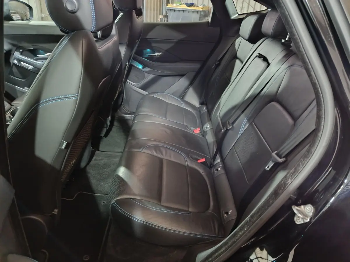 Vue intérieure côté droit des sièges arrière en cuir noir avec surpiqûres bleues d'un Jaguar E-PACE 2019.