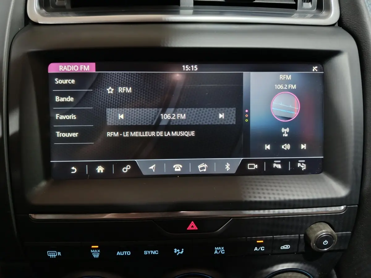 Écran tactile central allumé affichant la radio FM dans l’habitacle noir du Jaguar E-PACE P200 AWD 2019.