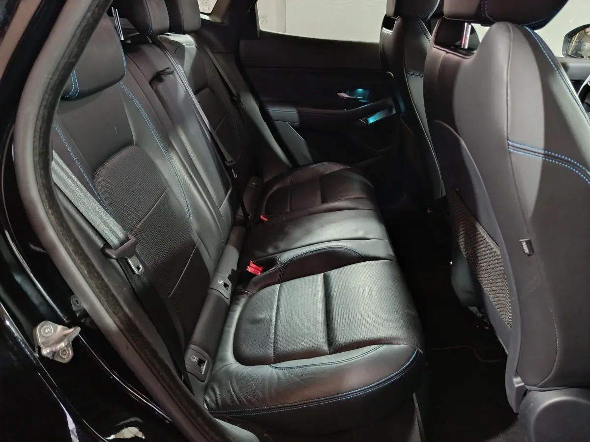 Vue intérieure côté gauche des sièges arrière en cuir noir avec surpiqûres bleues du Jaguar E-PACE 2019.