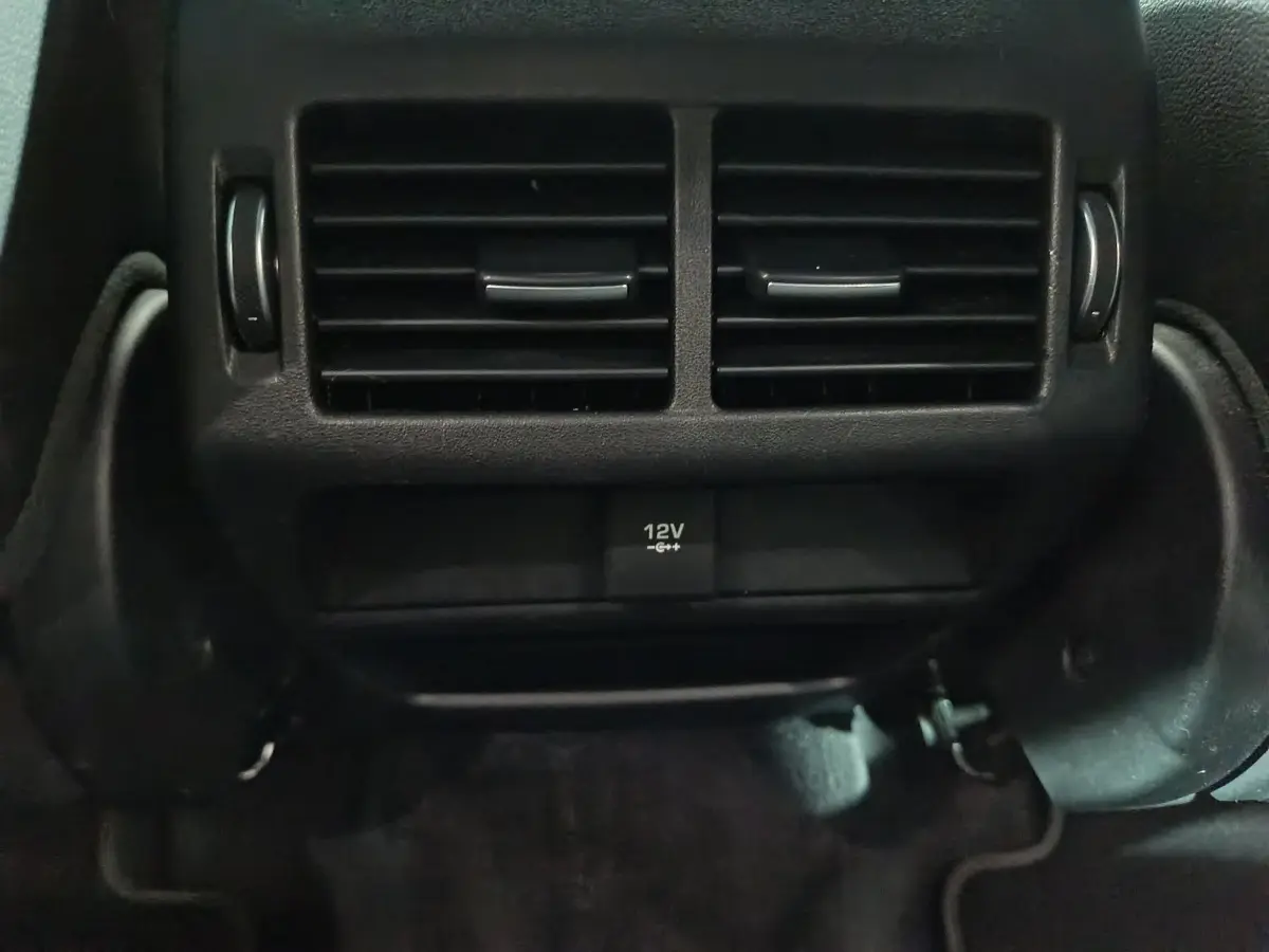 Gros plan sur la prise 12V et les aérateurs arrière noirs du Jaguar E-PACE P200 AWD R-DYNAMIC S 2019.