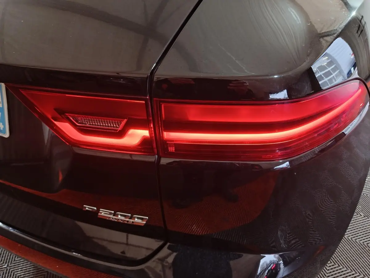 Gros plan sur le feu arrière droit rouge d'un Jaguar E-PACE noir P200 avec badge de modèle visible.