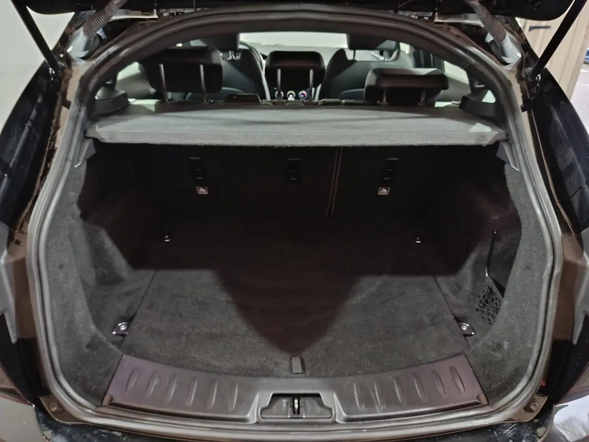 Vue arrière du coffre noir de la Jaguar E-PACE 2019, version R-DYNAMIC S, avec tablette cache-bagages déployée.