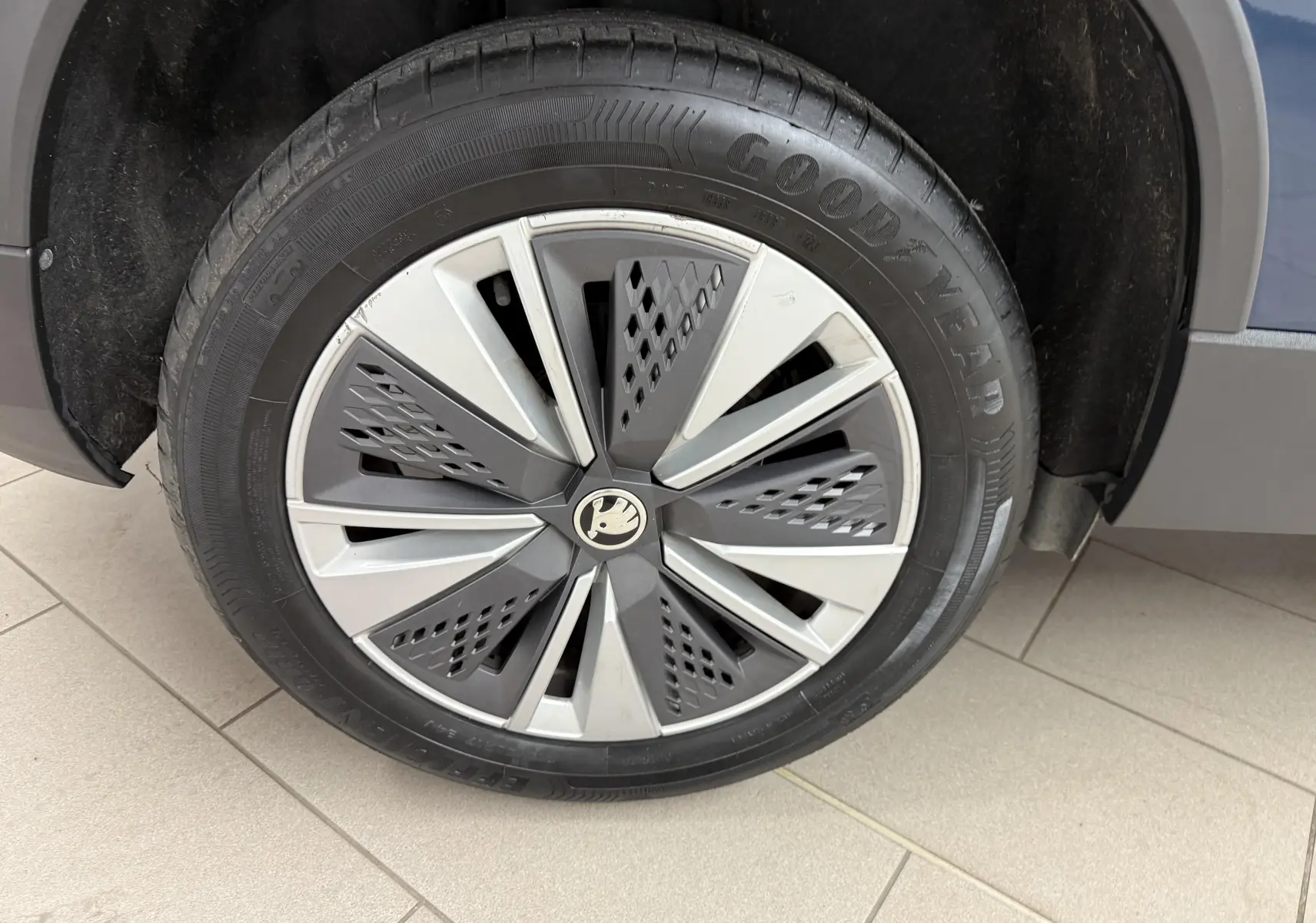 Gros plan sur la roue avant droite du Skoda Karoq bleu lave, avec jante design et pneu Goodyear visible.
