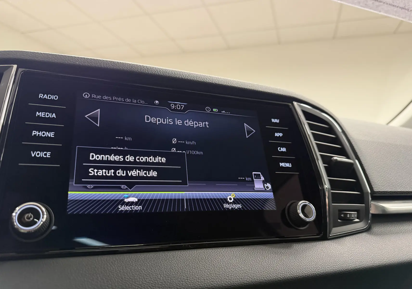 Écran tactile central du Skoda Karoq 2023 affichant les données de conduite, avec commandes autour et aérateurs à droite.