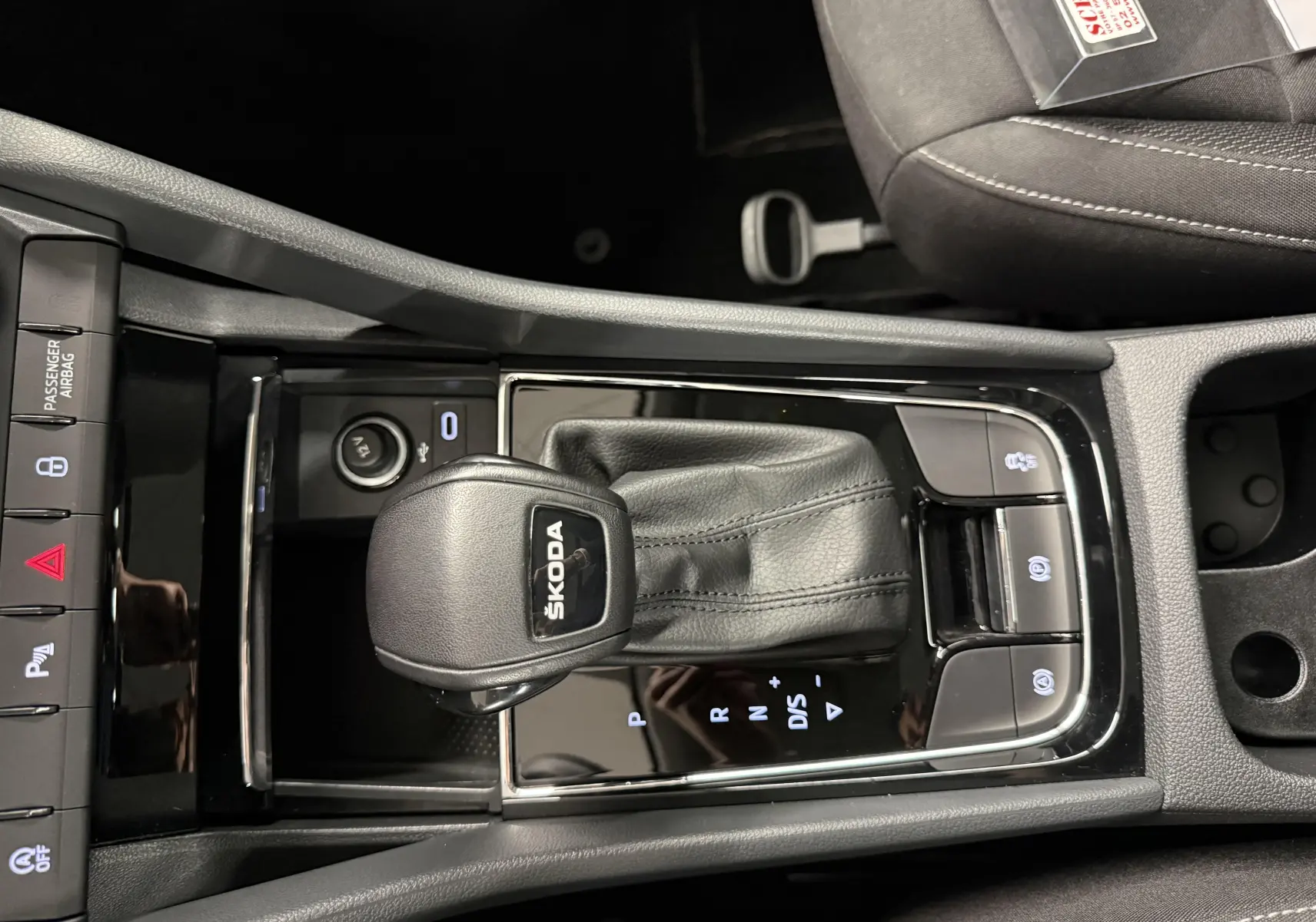 Vue rapprochée de la console centrale du Skoda Karoq 2023 avec levier de vitesses automatique et boutons de contrôle.