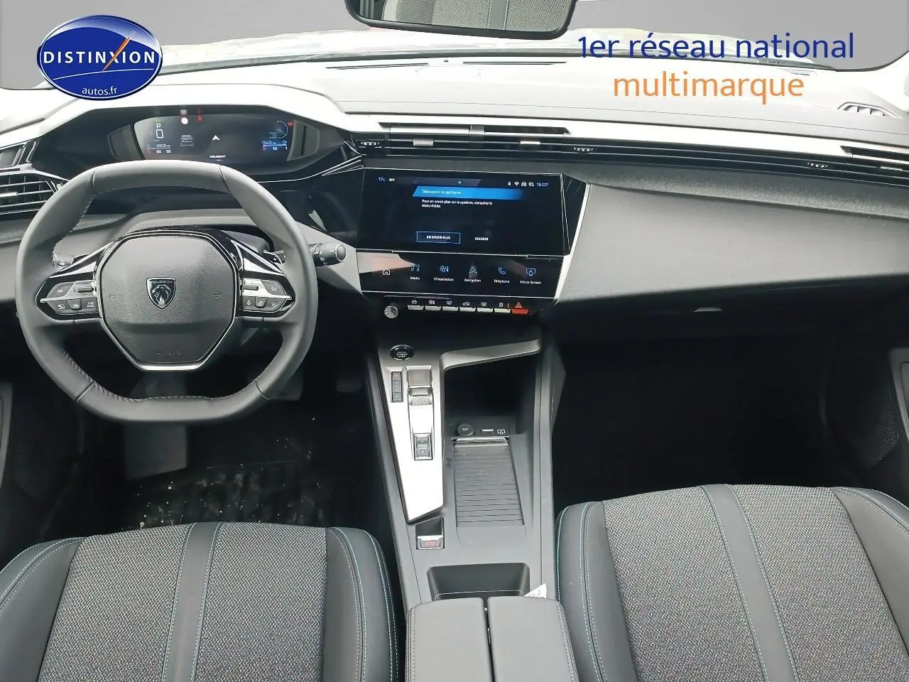 Vue intérieure avant de la Peugeot 308 SW 2025, tableau de bord et volant multifonction en noir et gris.