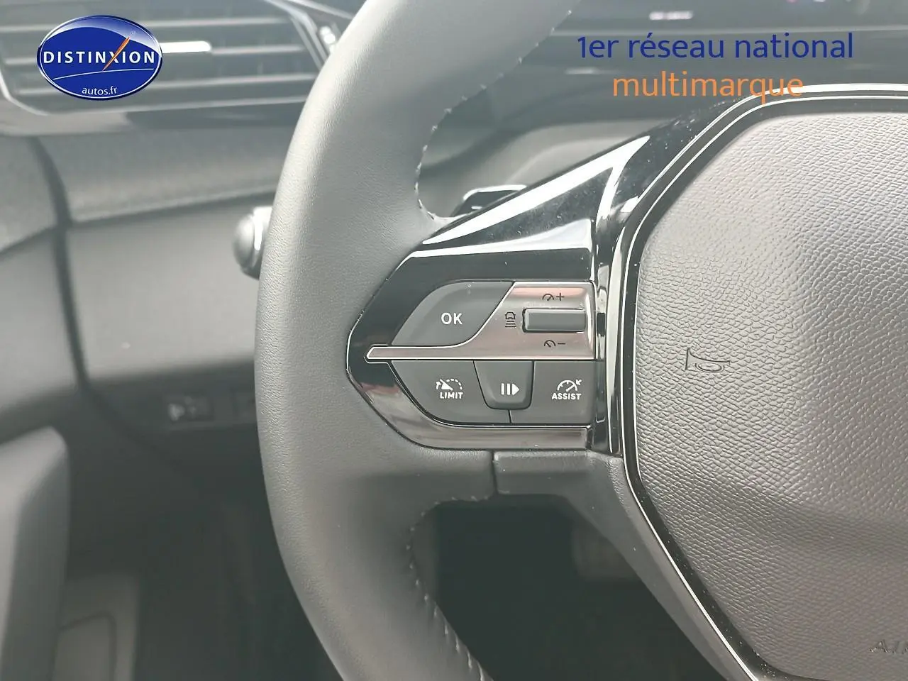 Gros plan sur le volant multifonction noir côté gauche du Peugeot 308 SW gris Sellenium, avec commandes de régulateur.