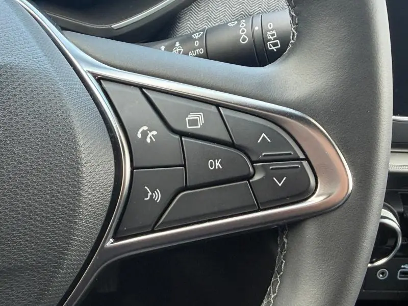 Détail des commandes au volant côté droit de la Renault Clio 1.6 E-Tech 145ch Rouge Flamme, boutons multifonctions et finition chrome.