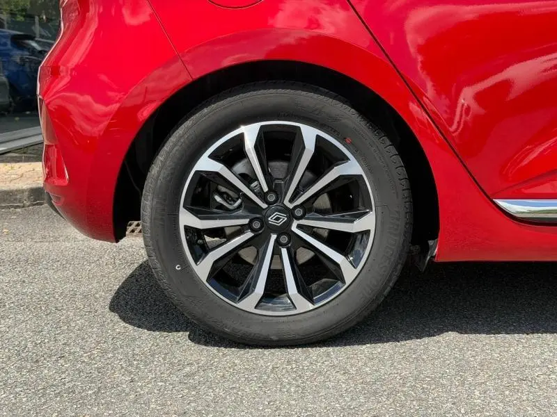 Gros plan sur la roue arrière droite de la Renault Clio 1.6 E-Tech rouge Flamme avec jante alliage au design moderne.